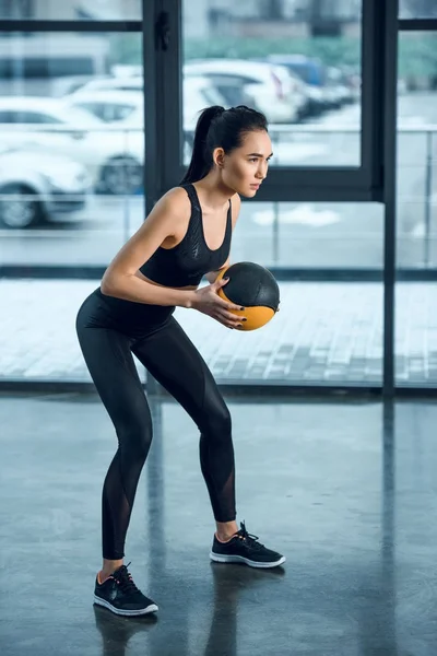 Jeune femme athlétique faisant de l'exercice avec balle au gymnase — Photo de stock