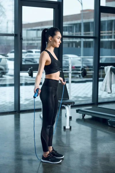 Young sporty woman with jumping rope at gym — Stock Photo