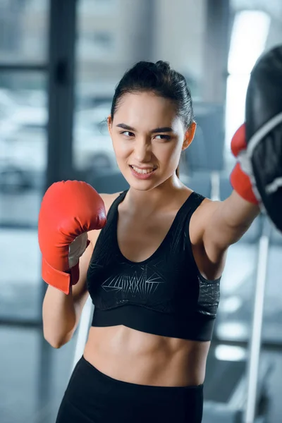 Ausdrucksstarke junge Boxerin beim Training im Fitnessstudio — Stockfoto