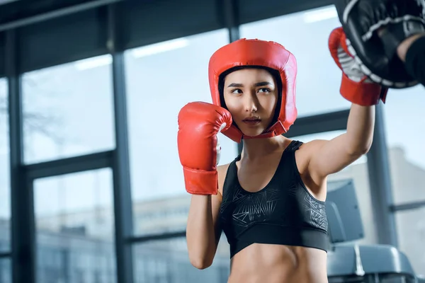 Equipaggiato giovane formazione pugile femminile in palestra — Foto stock