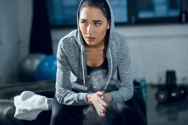 Jeune femme sportive applaudissant les mains avec talc avant l'entraînement à la salle de gym — Photo de stock