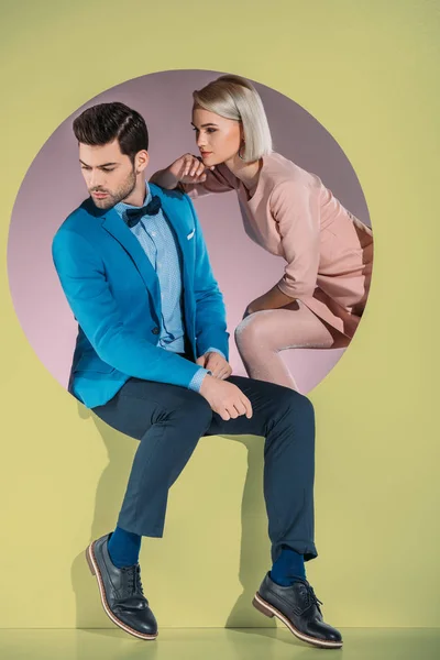 Hermosa pareja en ropa elegante mirando hacia abajo en amarillo - foto de stock