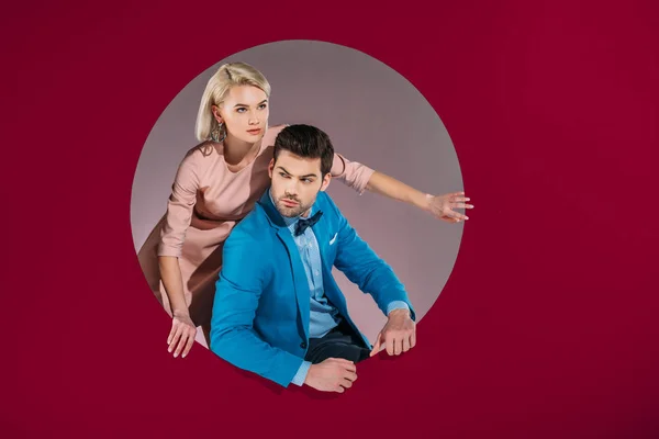 Beautiful couple in stylish clothes on burgundy — Stock Photo