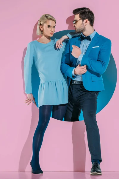 Attraktives stylisches Paar tritt durch Blende auf rosa — Stockfoto