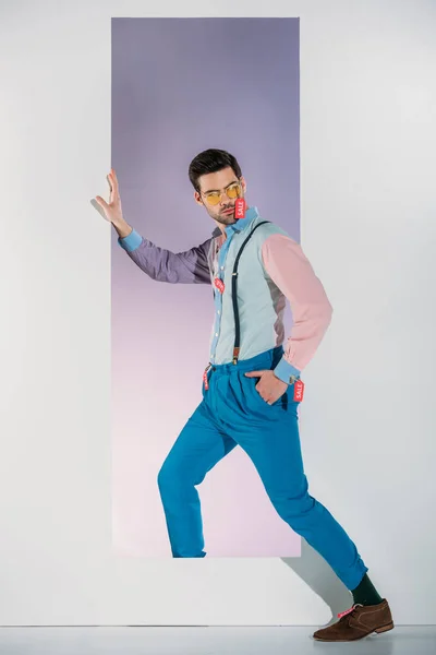 Hombre guapo en ropa elegante con etiquetas de venta de pie en el marco en blanco - foto de stock