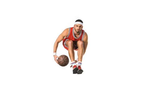 Young basketball player with ball jumping and looking at camera isolated on white — Stock Photo