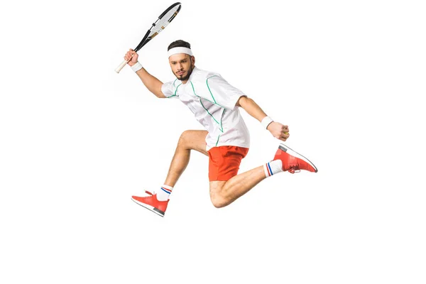 Young sportsman jumping while playing tennis isolated on white — Stock Photo