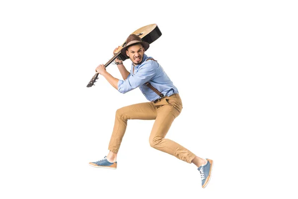 Joven enojado listo para golpear con la guitarra aislado en blanco - foto de stock