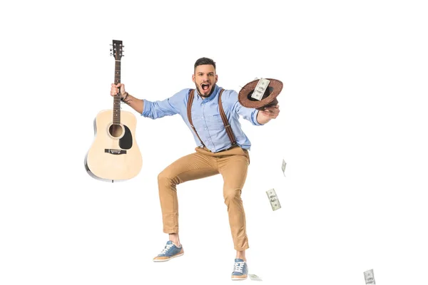 Aufgeregter junger Mann mit Gitarre und Hut und Dollarnoten auf weißem Hintergrund — Stockfoto