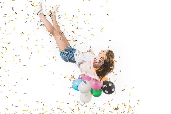 Giovane donna con palloncini colorati e coriandoli lucidi che cadono isolati su bianco — Foto stock
