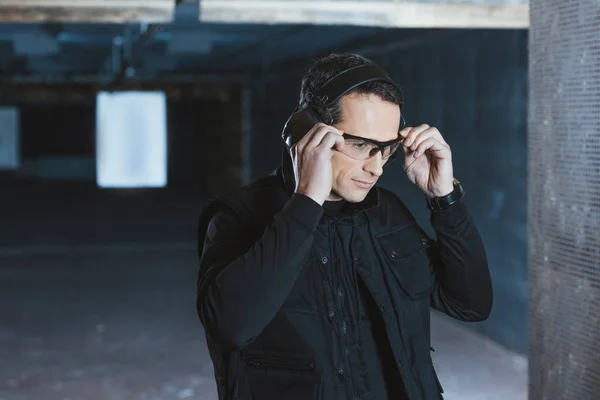 Handsome man wearing safety glasses in shooting range — Stock Photo