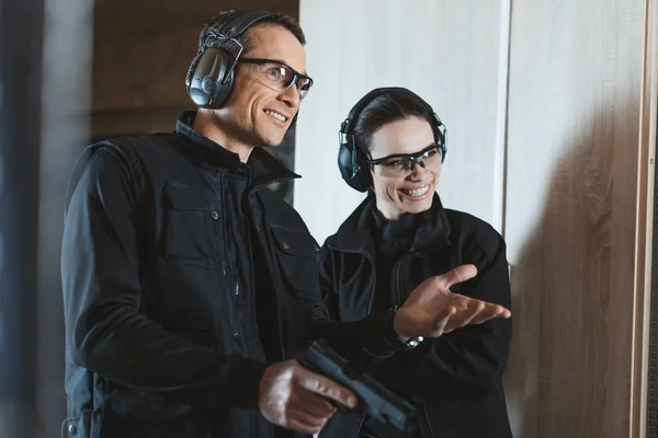 Smiling shooting instructor and customer in shooting gallery — Stock Photo