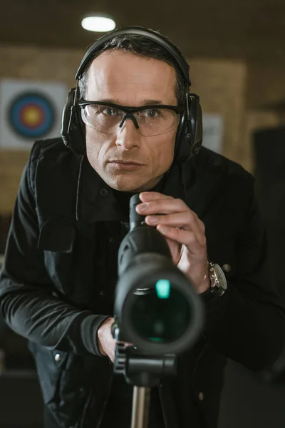 Handsome man with binoculars in shooting range — Stock Photo