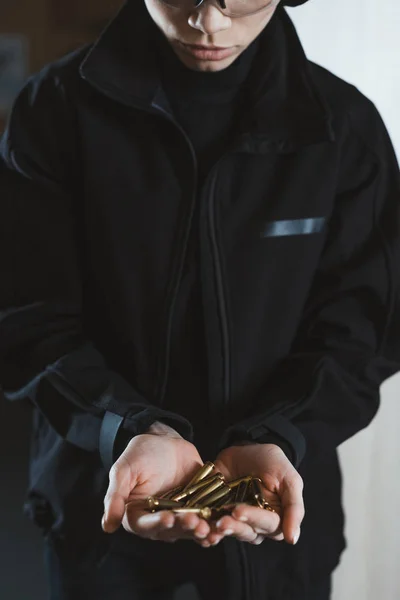 Cropped image of woman holding rifle bullets in hands — Stock Photo