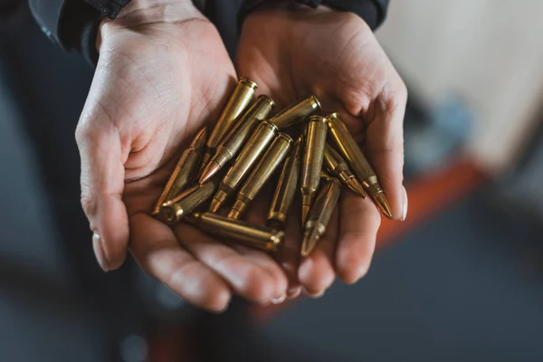 Cropped image of woman holding bullets in hands — Stock Photo