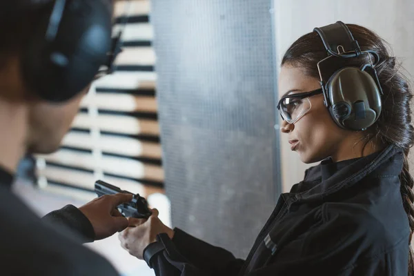 Instructor describing gun to client in shooting range — Stock Photo