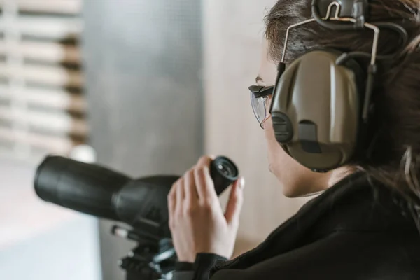 Side view of woman with binoculars in shooting range — Stock Photo