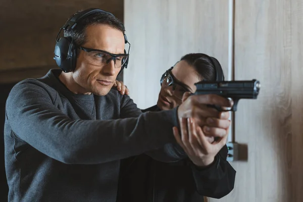 Ausbilderin beschreibt Klient, wie man im Schießstand schießt — Stockfoto