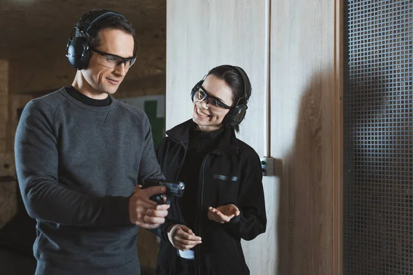 Smiling shooting instructor talking to client in shooting range — Stock Photo