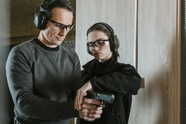 Instructor describing client how to hold gun — Stock Photo