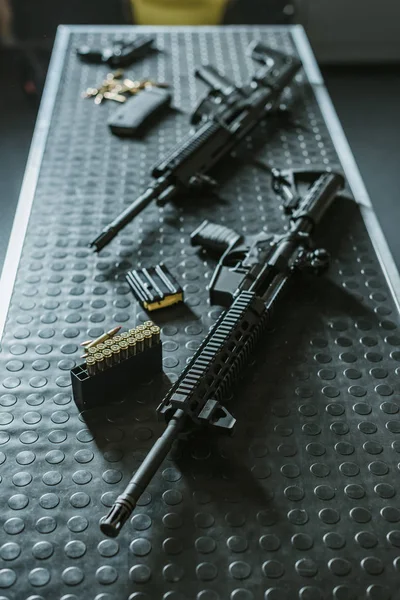 High angle view of rifles with bullets on table in shooting range — Stock Photo