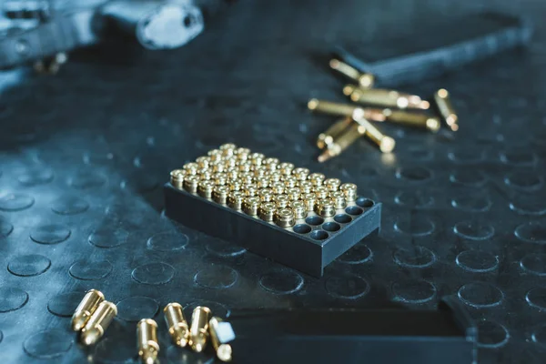 Cargadores de armas y rifles con balas en la mesa - foto de stock