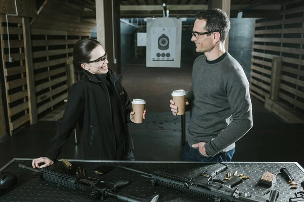 Client souriant et instructeur de tir boire du café dans le champ de tir — Photo de stock