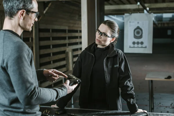 Ausbilder beschreibt Pistole an Kundin im Schießstand — Stockfoto