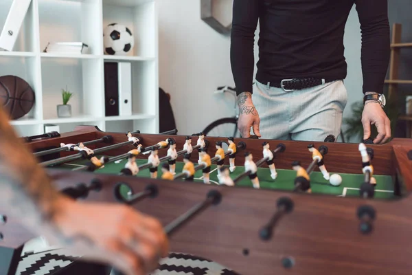 Обрезанный снимок людей, играющих в настольный футбол в офисе — стоковое фото