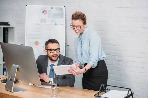 Erfolgreiche moderne Geschäftsleute, die im Büro mit digitalen Geräten arbeiten — Stockfoto