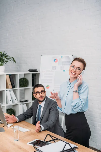 Angry businessman trying to work while his colleague talking by phone and annoying him — Stock Photo