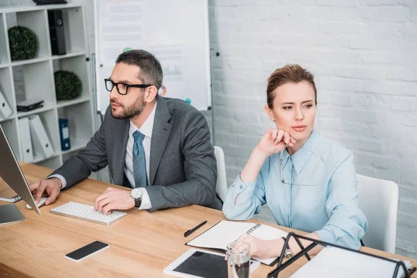 Sérieux gens d'affaires travaillant ensemble au bureau moderne — Photo de stock