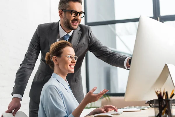 Felices socios de negocios exitosos trabajando juntos con la computadora - foto de stock