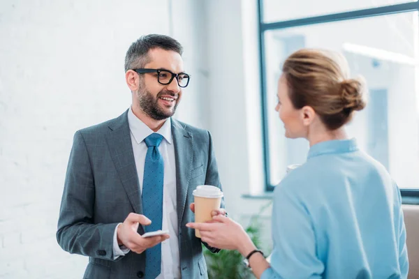 Business partners talking in office while drinking coffee — Stock Photo