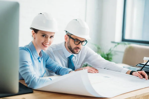 Arquitectos exitosos trabajando con el plan de construcción en la oficina - foto de stock