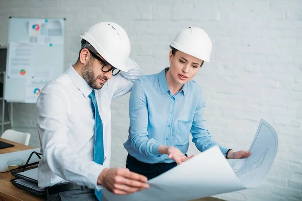 Serious architects discussing building plan at office — Stock Photo