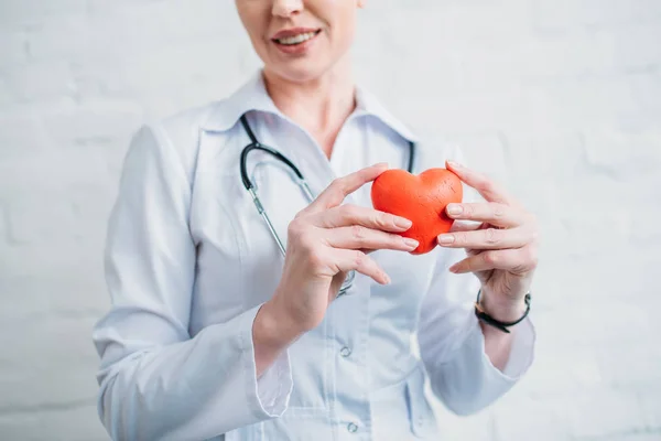 Cropped shot of female doctor with toy heart — Stock Photo