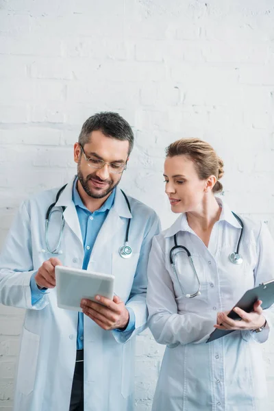 Ärzte arbeiten mit Tablet und Klemmbrett — Stockfoto
