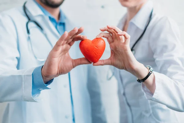 Обрізаний знімок лікарів, які тримають іграшкове серце разом — стокове фото