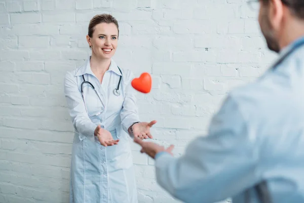 Лікарі кидають іграшкове серце один одному — стокове фото