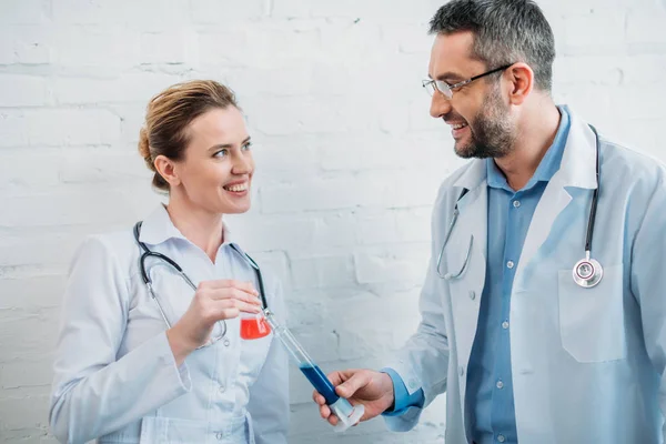 Male and female doctors with laboratory flasks — Stock Photo