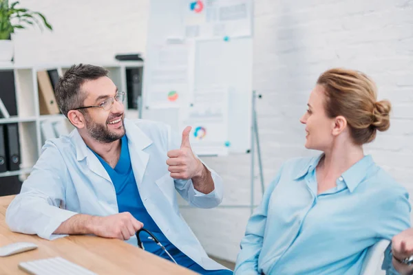 Happy doctor showing thumb up to patient — Stock Photo