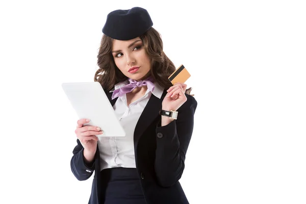 Attrayant hôtesse réfléchie avec tablette et carte de crédit isolé sur blanc — Photo de stock