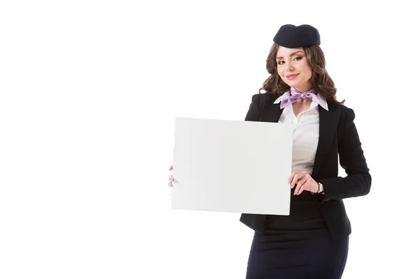 Beautiful stewardess holding empty board and looking at camera isolated on white — Stock Photo