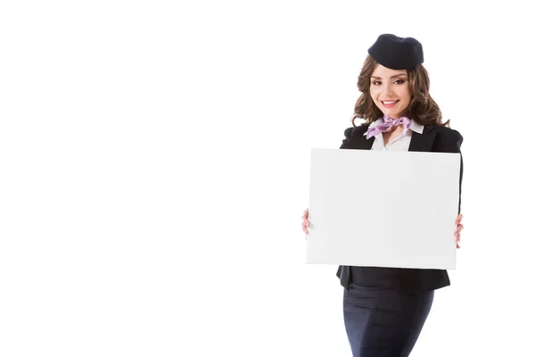 Smiling attractive stewardess holding empty board isolated on white — Stock Photo