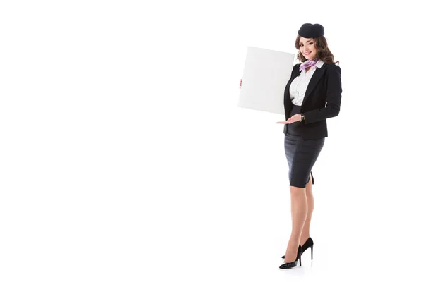 Attractive stewardess holding empty board and looking at camera isolated on white — Stock Photo