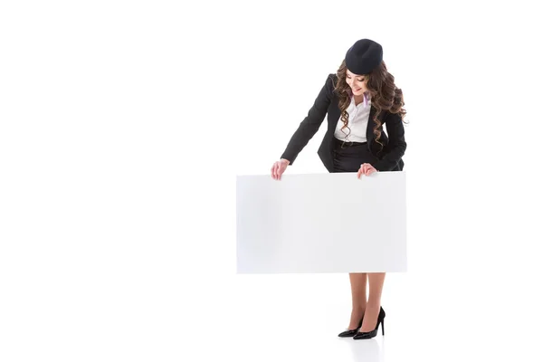 Beautiful stewardess looking at empty board isolated on white — Stock Photo