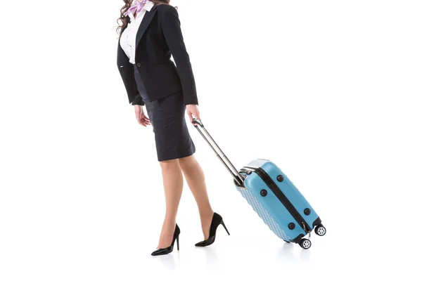 Обрезанное изображение стюардессы, идущей с чемоданом, изолированным на белом — стоковое фото
