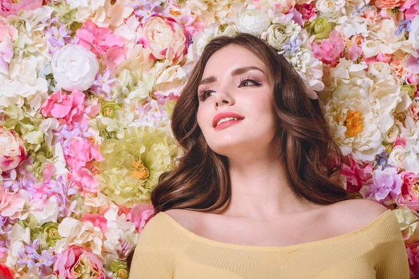 Beautiful girl with flowers wreath on head looking away — Stock Photo