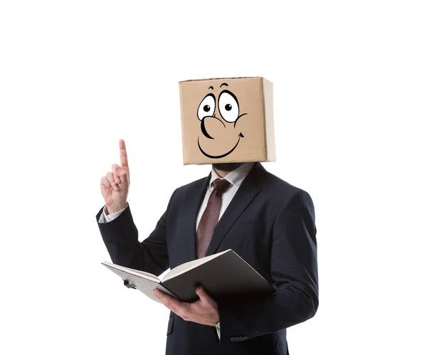 Hombre de negocios con caja de cartón en la cabeza sosteniendo la carpeta y apuntando hacia arriba con el dedo aislado en blanco - foto de stock